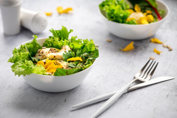 Salad with green lettuce, avocado, petals, egg and seeds. Healthy eating concept.