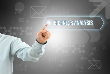 Business man touch a button on an imaginary screen with text BUSINESS ANALYSIS
