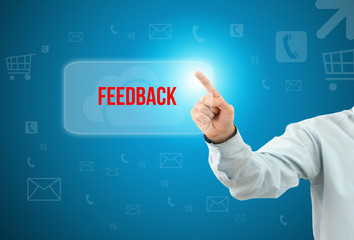 Obraz premium Business man touch a button on an imaginary screen with text FEEDBACK