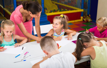 Fototapeta premium children sitting together and drawing in class at school