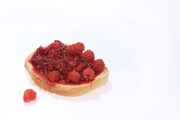 Red raspberry with toast on white isolated background, selective focus, copy space .