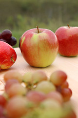 red apples , grapes on wooden table