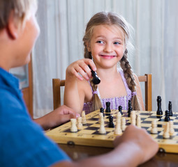 children at chess board indoors
