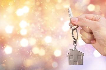 House key in hand on blurred background