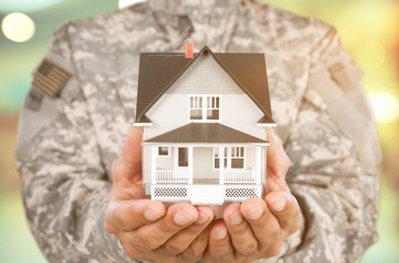 Soldier Holding a Model of House