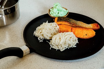 Pan with salmon, noodle and dip.