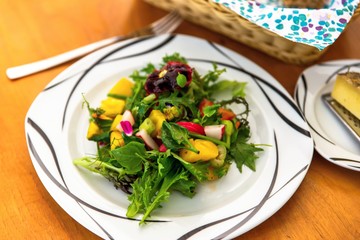 Vegetable salad with flowers on table.