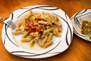 Italian penne bolognese in white plate.