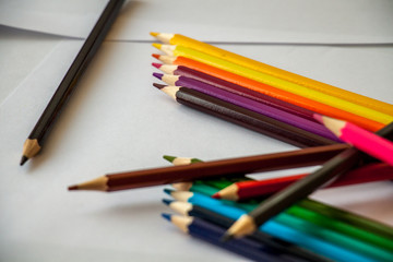 colored pencils are lying on white sheets of paper