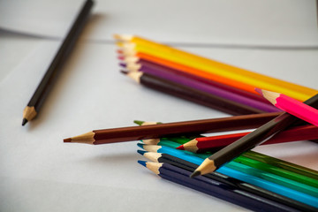 Fototapeta premium colored pencils are lying on white sheets of paper