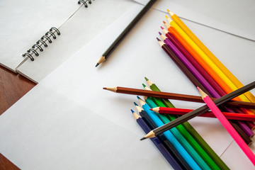 colored pencils are lying on white sheets of paper