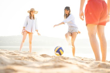 Group of young people playing with ball at the beach. Young friends enjoying summer holidays on a sandy beach