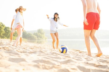 Group of young people playing with ball at the beach. Young friends enjoying summer holidays on a sandy beach