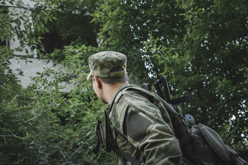 the military looks in the direction of an abandoned house in the woods