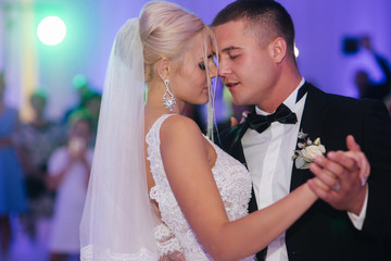 Portrait of first dance of stylish wedding couple. Handsome groom and elegant bride in the...