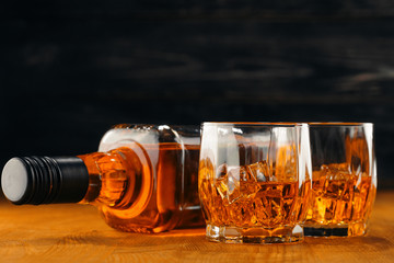 Still life. Whiskey in to glass. Wooden table