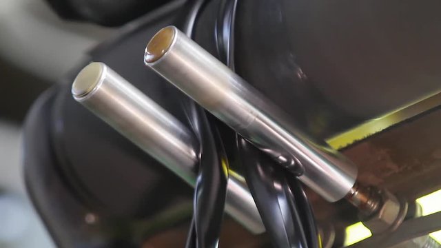 Rubber tape is fed into machine for further forming and processing at a chemical plant. Machine with large shafts kneads rubber compound and forms a rubber band. Recycling rubber in a large factory.