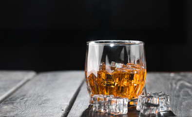 Still life. Whiskey in to glass. Wooden table