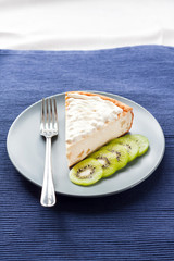 Homemade cottage cheese and semolina cake with kiwi fruit and cream on a plate