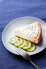 Homemade cottage cheese and semolina cake with kiwi fruit and cream on a plate