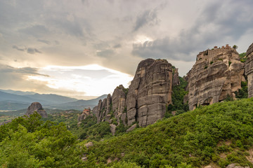 Meteora - incredible sandstone rock formations.  The Meteora area is on UNESCO World Heritage List since 1988. Valley between rocks at sunset. Greece