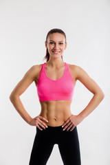 Fototapeta na wymiar Sport young woman athlete standing looking at camera with her hands on hips on white background.