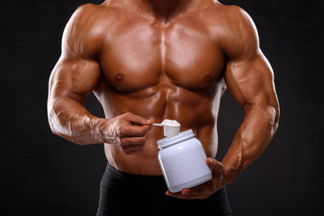 Close up of Muscular Men Taking Nutritional Supplements