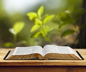 Open book on old wooden table.