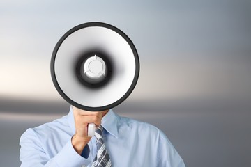 Young businessman talking on the megaphone on white background