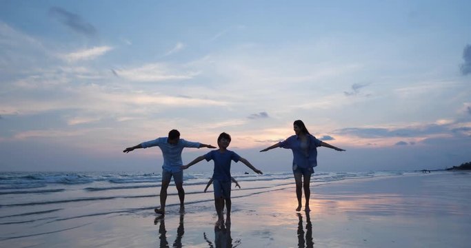 Asian family happy running feeling freedom same bird on the beach summer together in holiday. Concept of family, travel, summer and vacation. 4k resolution.
