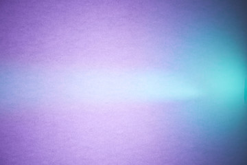 Turquoise ray of light cuts through the textural purple and blue blurred background