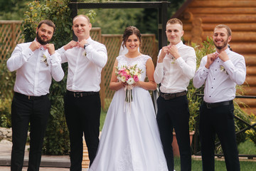 Charming bride stand by the groomsman on the backyard
