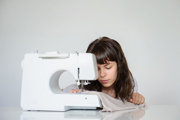 close up photo of a sexy brunette working at the sewing machine