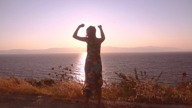 The Happy Woman Dancing stock video is an excellent piece of video that shows beautiful woman dancing at the wonderful place near the sea in the sunset . 