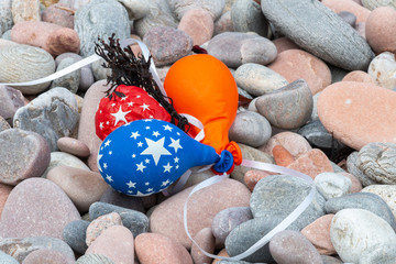 Party balloons which have drifted and landed on a rocky beach