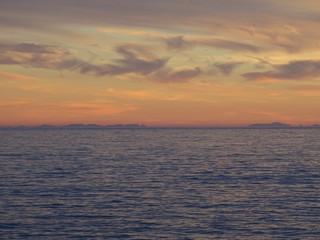 nubes multicolores en atardecer dorado sobre mar mediterraneo con estrecho de gibraltar en el...