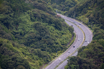 Aerial view of highway through forested mountains of Japan