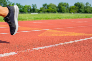 Close-up feet of woman on track, runner on running lane