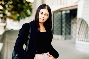 beautiful girl with brunette hair, posing outside, hipster style, portrait, black jacket, brash girl, sunglasses, street, backpack, Fall fashion 