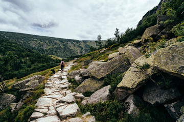 Young woman on the trail in Giant Mountains (Karkonosze), authentic travel experience. 