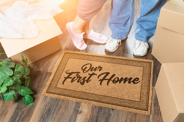 Man and Woman Unpacking Near Our First Home Welcome Mat, Moving Boxes and Plant