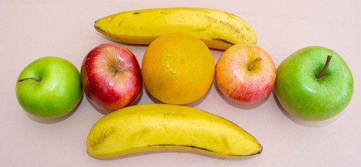 Fruits in a row next to two bananas on the table