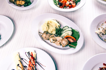 mashed potatoes with barbecue, fresh vegetable salad and other dishes on the table
