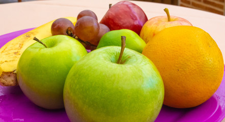 Some colorful fruits on a tray on table close up