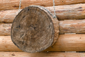 The target for hand throwing weapons made from saw cut is suspended on chains on the brushed log...