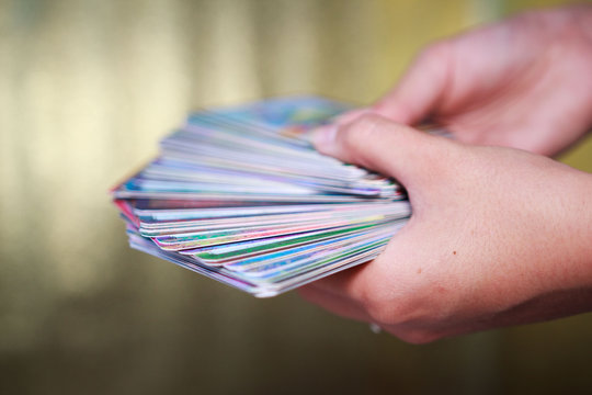 fortune-tellers' hands hold a deck of tarot cards on a gold background. 63 full oracle deck.