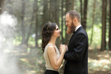 bride and groom standing in the woods.photo with cloud effect