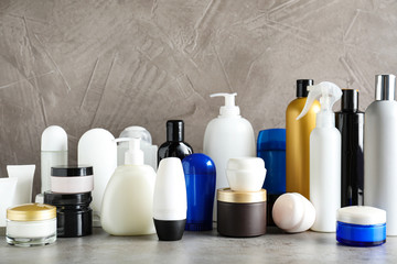 Different body care products on table against grey background