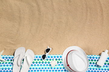 Flat lay composition with different beach objects on sand. Space for text