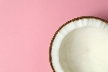 Fresh coconut half on pink background, top view. Space for text